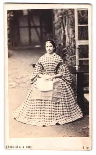 Fotografie Brading & Co., Newport / I.W., junge Engländerin im karierten Kleid mit Schürze