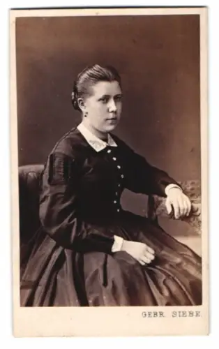 Fotografie Gebr. Siebe, Stettin, hübsche junge Frau im dunklen Kleid mit nach hinten gebundenen Haaren