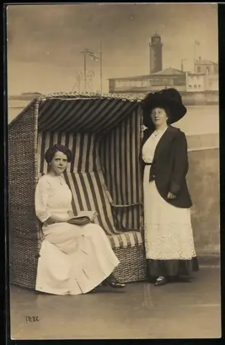 Foto-AK Zwei Frauen am Strandkorb, Im Hintergrund Leuchtturm, Studiokulisse