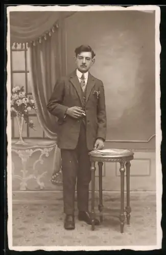 Foto-AK Eleganter Herr raucht in einer Studiokulisse