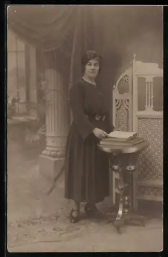 Foto-AK Frau mit Buch in einer Studiokulisse