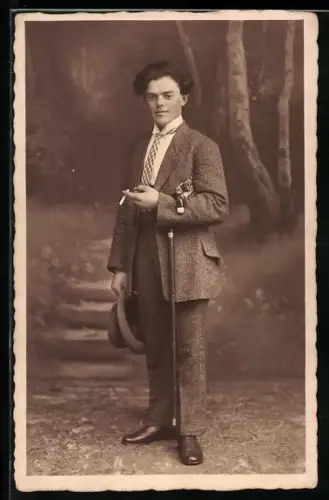 Foto-AK Eleganter Herr raucht in einer Studiokulisse