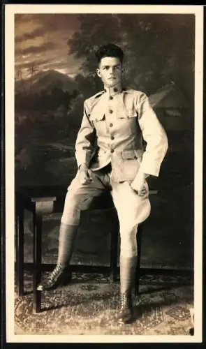 Foto-AK Junger Mann am Tisch in einer Studiokulisse