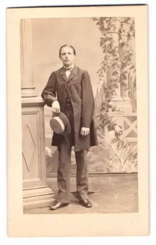 Fotografie Photog. Verein, Berlin, Portrait junger Mann Ernst Rauff im Anzug mit Sommerhut vor einer Studiokulisse