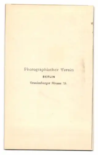 Fotografie Photog. Verein, Berlin, Portrait junger Mann Ernst Rauff im Anzug mit Sommerhut vor einer Studiokulisse