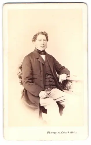 Fotografie Lutze & Witte, Berlin, Herr im dunklen Anzug mit Locken