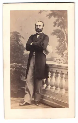 Fotografie Straube & Friese, Berlin, Herr im feinen Anzug mit heller Melone vor einer Studiokulisse