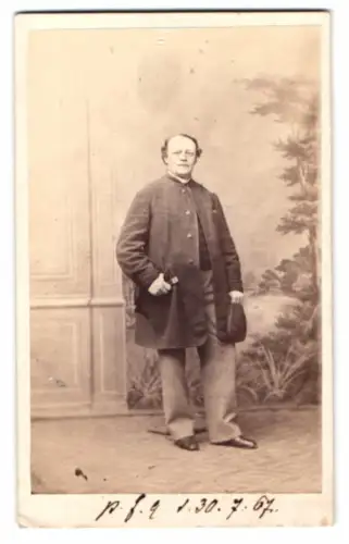 Fotografie L. Harnecker, Wrietzen, Mann im bürgerlichen Anzug mit Hut vor einer Studiokluisse, 1867