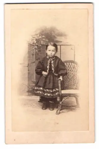 Fotografie A. Borkheim, Greifenberg i. Pomm., niedliches kleines Kind im Kleid nebst Korbstuhl