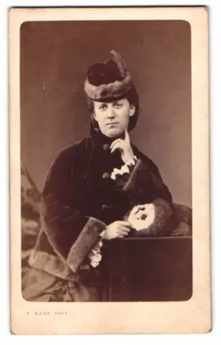 Fotografie F. Raps, Coeln, junge Frau im Samt Winterkleid mit Hut und Muff