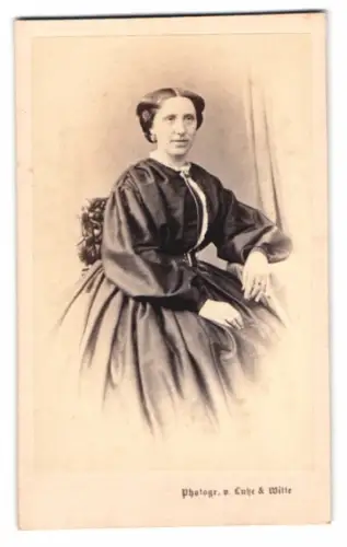 Fotografie Lutze & Witte, Berlin, Dame im dunklen Kleid mit Ohrringen