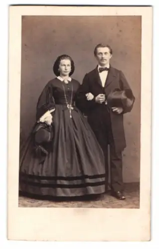 Fotografie junges Paar im dunklen Kleid und Anzug mit Hut und Zylinder