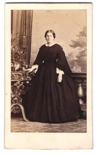 Fotografie Meltzer, Berlin, Dame im dunklen Kleid vor einer Studiokulisse