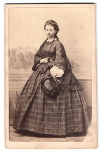 Fotografie Portrait hübsche junge Frau im karierten Kleid vor einer gemalten Studiokulisse