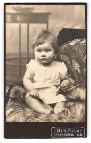Fotografie Alb. Fick, Cadenberge, Kleinkind auf einem Fell