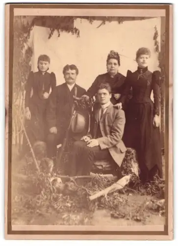 Fotografie unbekannter Fotograf und Ort, Gruppenportrait in einer Studiokulisse