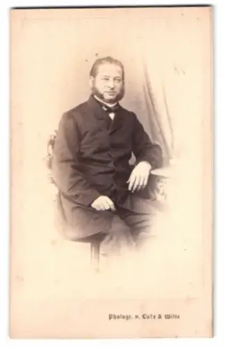 Fotografie Lutze & Witte, Berlin, Kleine Dom-Strasse, Porträt eines sitzenden Mannes mit Backenbart