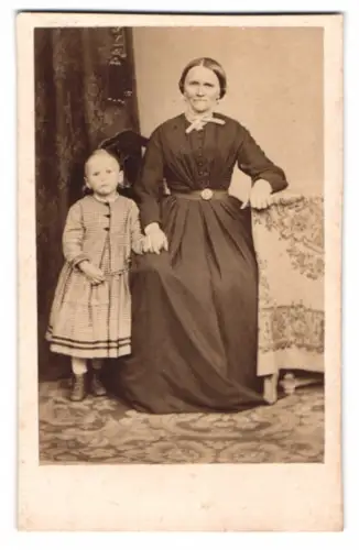 Fotografie unbekannter Fotograf und Ort, Frau mit Kind in traditioneller Kleidung