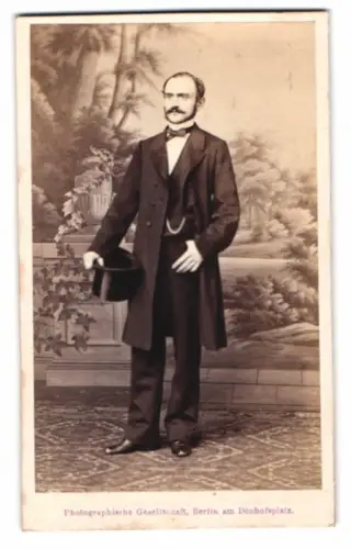 Fotografie Photg. Gesell., Berlin, Dönhofsplatz, eleganter Mann mit Zylinder vor einer Studiokulisse
