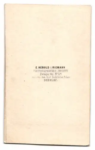 Fotografie E. Herold & Riemann, Breslau, Zwinger Str. 4, Stehender Herr neben kunstvoll verziertem Tisch