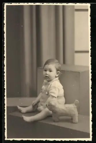 Foto-AK Kleinkind sitzt neben einem Plüschtier