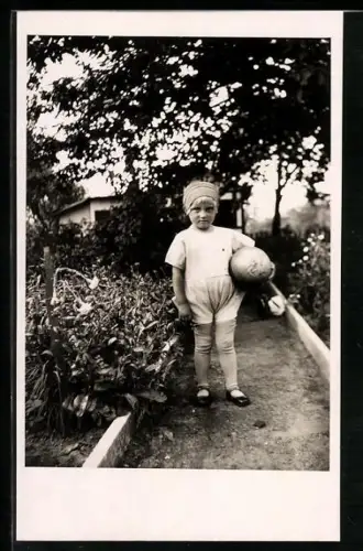 Foto-AK Kleinkind mit einem Ball im Garten