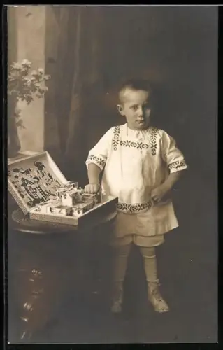 Foto-AK Junge steht neben einem Kasten mit Klötzen