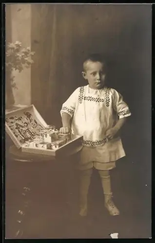 Foto-AK Kleiner Junge mit einem Kasten voller Klötze