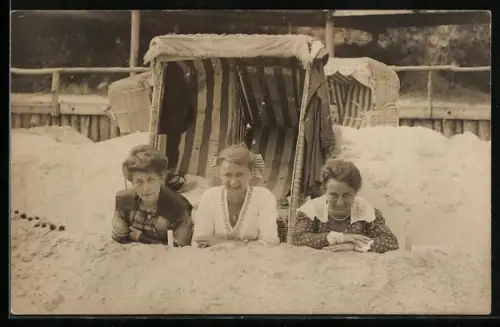 Foto-AK Drei Frauen vor Strandkorb liegen auf einem Sandwall