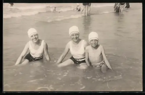 Foto-AK Drei Kinder in Badekleidung sitzen in flachem Wasser