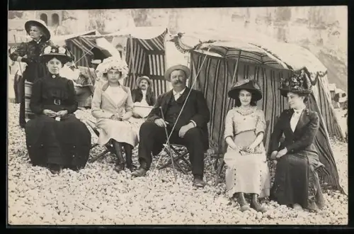 AK Le Tréport, Frauen und Männer am Steinstrand sitzen vor Strandkörben