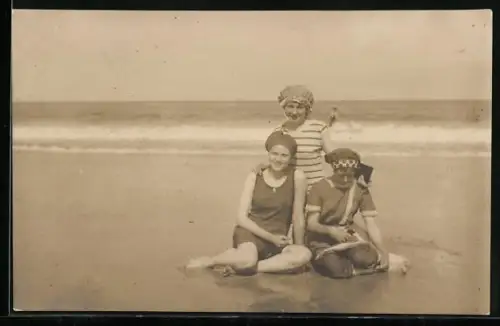 Foto-AK Norderney, Drei Frauen in Badeanzügen sitzen am Strand
