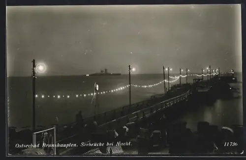 AK Brunshaupten, Seebrücke bei Nacht, im Hintergrund Panzerschiff Admiral Scheer