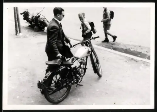 Fotografie Motorrad, Mann schiebt Moped an Schulknaben vorbei