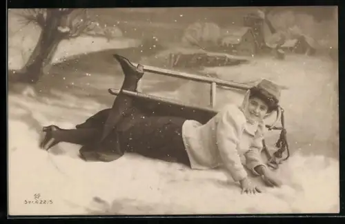 AK Frau liegt lächelnd im Schnee neben ihrem Schlitten