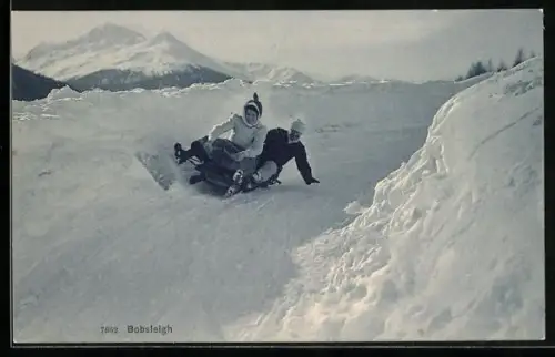 AK Mann und Frau rasen auf einem Bob-Schlitten die Piste hinunter