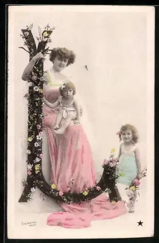 AK Mutter posiert mit ihren Kinder neben dem Buchstaben L