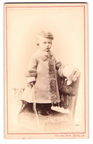 Fotografie Th. Prümm, Berlin, niedlicher kleiner Knabe im Wintermantel mit Mütze