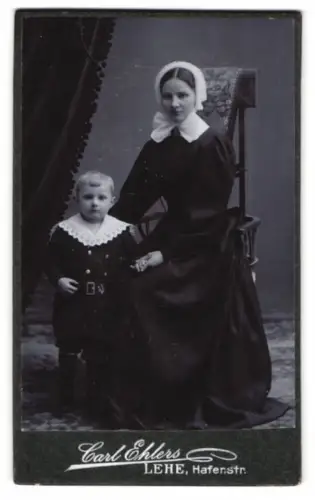 Fotografie Carl Ehlers, Lehe, junge Mutter im dunklen Kleid mit Haube und ihrem Sohn, Mutterglück
