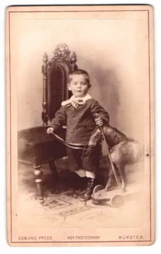Fotografie Edmudn Frede, Münster i. W., junger Knabe mit seinem Holzpferd auf Rollen