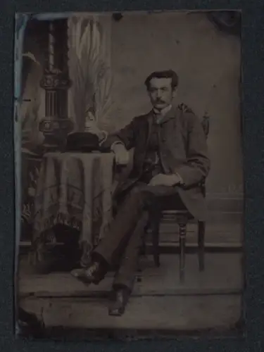 Fotografie Ferrotypie junger Mann im feinen Anzug mit Melone auf dem Tisch