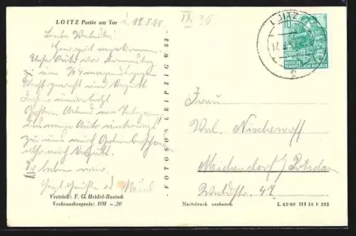 AK Loitz, Partie am Tor mit Passanten und Kirchturm