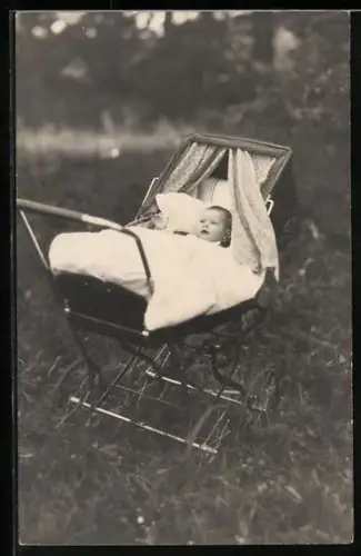 Foto-AK Baby im Kinderwagen auf einer Wiese