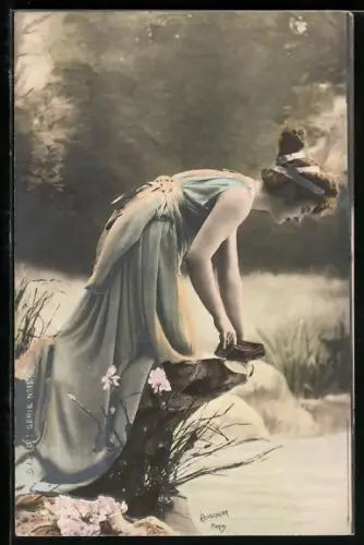 Foto-AK Atelier Reutlinger, Paris: Frau in wallendem Kleid beugt sich über Stein und sieht ins Wasser