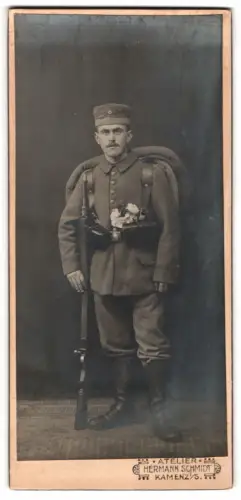 Fotografie Atelier Hermann Schmidt, Kamenz i. S., Infanterist in Uniform mit Gewehr und Krätzchen, Kriegsausmarsch