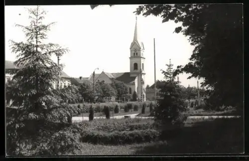 AK Jimbolia, Kirche mit Nachbarhäusern und Grünanlage