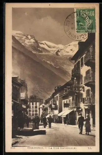 AK Chamonix, La Rue Nationale avec vue sur les montagnes enneigées