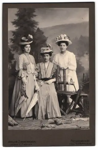 Fotografie Atelier Zimmermann, Freudenstadt, drei junge Damen in Sommerkleidern mit Schirm vor einer Studiokulisse