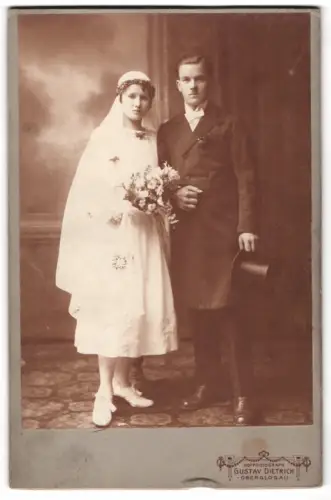 Fotografie Gustav Dietrich, Oberglogau, Brautpaar im Hochzeitskleid mit Brautstrauss und im Anzug mit Zylinder