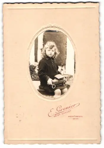 Fotografie E. Grenier, Montreuil, junges franz. Mädchen mit ihrem Blechauto auf dem Schoss, Spielzeug Auto